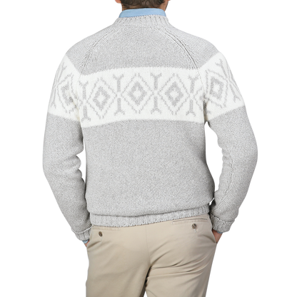 A person wearing a Gran Sasso Grey Eco Cashmere Norwegian Crewneck Sweater, featuring a white geometric pattern on the back, pairs it with beige pants and stands against a plain background.