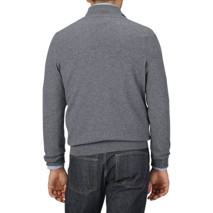 A person wearing a Grey Melange Cashmere 1/4 Zip Sweater from Gran Sasso and blue jeans is shown from the back, standing against a plain background.