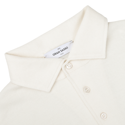 A close-up of an Ivory Merino Wool One-Piece Collar Polo Shirt with long sleeves, featuring three buttons and a 'Gran Sasso' label on the inside of the collar.