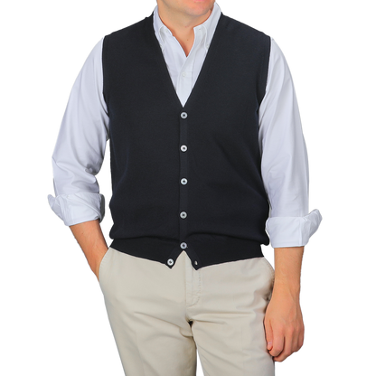 A person wearing a white dress shirt, beige pants, and a Gran Sasso Navy Blue Extra Fine Merino Wool Vest stands against a plain gray background.