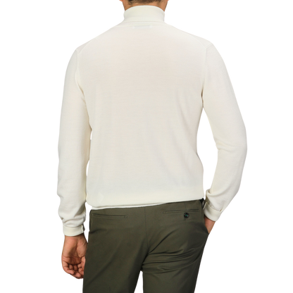 An individual wearing a Gran Sasso Off White Extra Fine Merino Rollneck and dark pants, facing away from the camera.