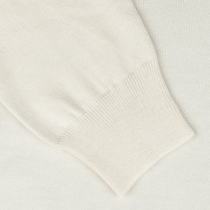 Close-up of the Gran Sasso Off White Extra Fine Merino Rollneck sweater sleeve, featuring a ribbed cuff on a matching textured surface.