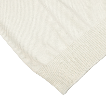 Close-up of the corner of an Off White Extra Fine Merino Rollneck by Gran Sasso, showcasing its intricate knit texture and stitch pattern.