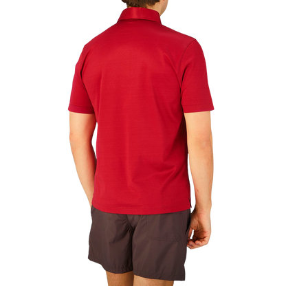 The back view of a man wearing a Raspberry Red Cotton Filo Scozia polo shirt by Gran Sasso.