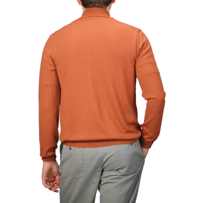 Individual dressed in a Sienna Brown Extrafine Merino Wool Zip Cardigan by Gran Sasso and gray pants, standing with their back to the camera against a simple backdrop.