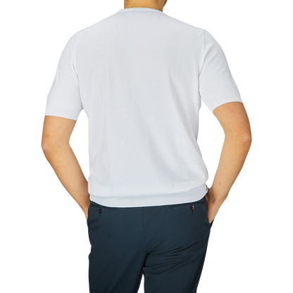 Rear view of a man wearing a Gran Sasso White Organic Cotton T-shirt and dark trousers, standing against a light gray background.