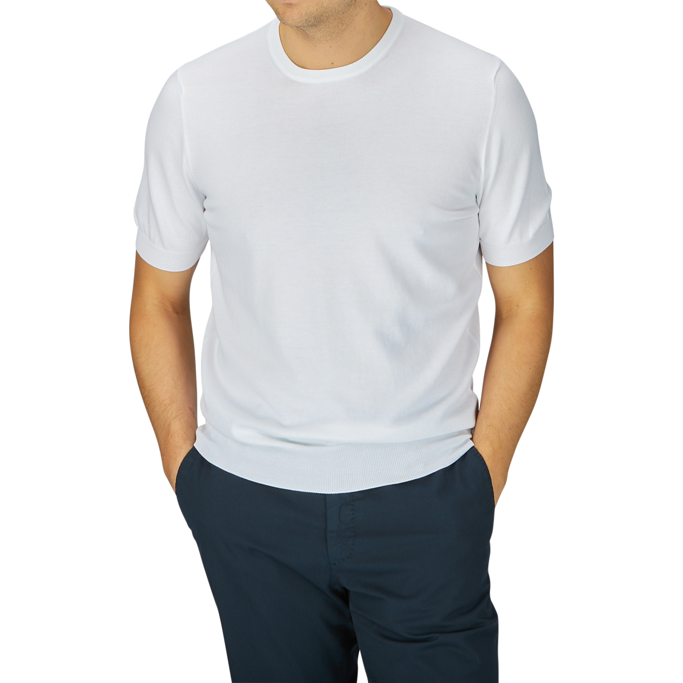 A man wearing a Gran Sasso white organic cotton knitted t-shirt and navy blue pants, standing with his arms slightly away from his sides.