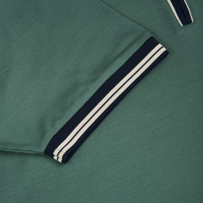 Close-up of the Green Cotton Filo Scozia Zip Polo Shirt by Gran Sasso, highlighting the textured fabric, sleeve, and collar with navy trim and double white stripes. , available at Richard Gelding Mayfair