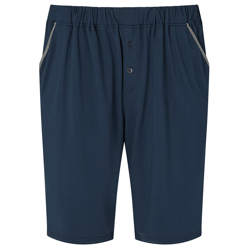 The Homebody Navy Modal Jersey Pyjama Shorts feature an elastic waistband, two side pockets with light gray trim, a two-button fly, and are crafted from soft Modal Sens fabric for luxe bedtime comfort and a simple, casual look. , available at Richard Gelding Mayfair
