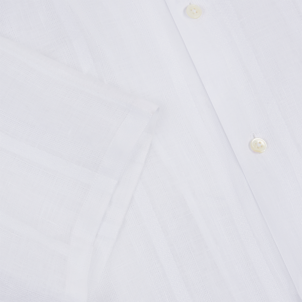 Close-up of the Maurizio Baldassari White Linen Short Sleeve Bowling Shirt, highlighting its white buttons, neatly folded sleeve, and subtly sheer, breathable linen fabric with a visible weave pattern. , available at Richard Gelding Mayfair