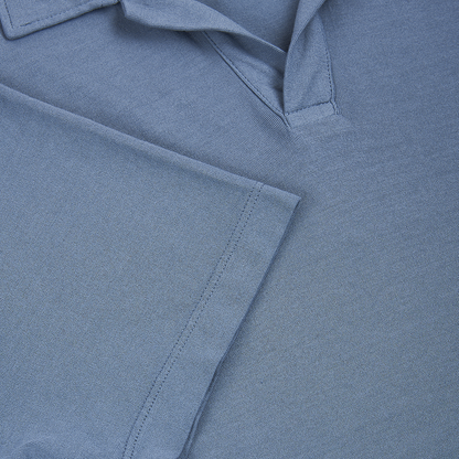Close-up of the Altea Blue Ice Cotton Polo, showcasing its folded sleeve and collar. The soft, textured cotton fabric features visible stitching along the hem and placket. This classic blue polo looks crisp, clean, and unworn. , available at Richard Gelding Mayfair