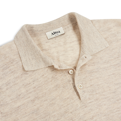 A close-up of the Altea Beige Cotton/Linen Polo for men shows a soft collar, two cream buttons, a subtle textured pattern, and a white inner collar label with the brand name “Altea” in black. , available at Richard Gelding Mayfair