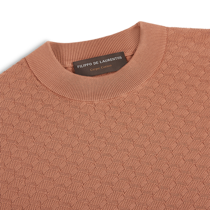 A close-up of the Filippo de Laurentiis Peach 3D Weave Crepe Cotton T-Shirt features a rust hue, subtle geometric texture, and a label inside the collar highlighting the brand and crepe cotton fabric. , available at Richard Gelding Mayfair