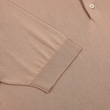 Close-up of the Peach Sea Island Cotton Polo Shirt by Filippo de Laurentiis, featuring soft, lightly textured luxury cotton knit with ribbed cuffs and two tan buttons on the placket. , available at Richard Gelding Mayfair