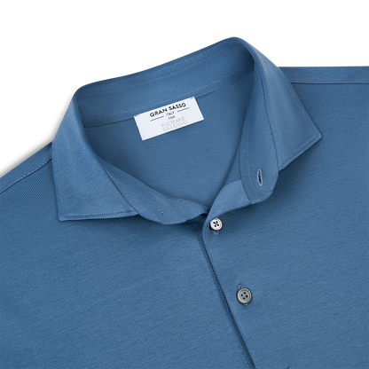 A Blueberry Navy Filo Scozia Polo by Gran Sasso, featuring a pointed collar and three buttons. The inner tag reads "GRAN SASSO" and "MADE IN ITALY." Made from premium filo scozia cotton and displayed flat on a white background. , available at Richard Gelding Mayfair