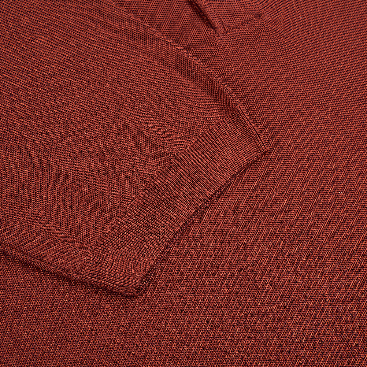 Close-up of the Gran Sasso Rust Red Silk Pique Polo, highlighting the ribbed cuff and sleeve. The snug ribbing contrasts with the smoother textured knit of this long-sleeved silk garment. , available at Richard Gelding Mayfair