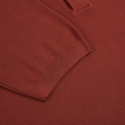 Close-up of the Gran Sasso Rust Red Silk Pique Polo, highlighting the ribbed cuff and sleeve. The snug ribbing contrasts with the smoother textured knit of this long-sleeved silk garment. , available at Richard Gelding Mayfair