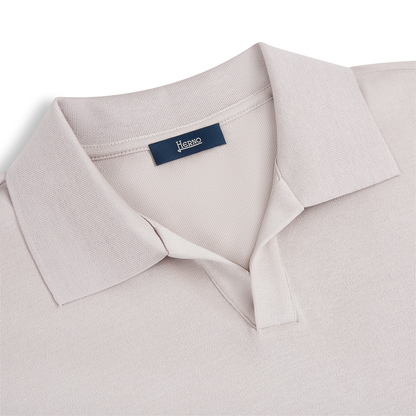 A close-up of the Herno Light Grey Cotton Knitted Open Neck Polo, showcasing its minimalist design and short sleeves. The shirt is laid flat on a white background, with the Herno label sewn inside the collar. , available at Richard Gelding Mayfair
