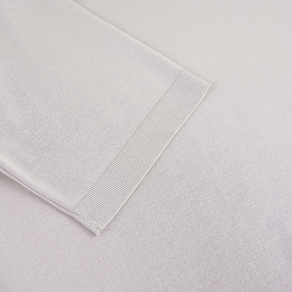 A close-up of the Herno Light Grey Cotton Knitted Open Neck Polo shows fine, even stitching and a ribbed hem, with subtle shadows highlighting the texture and weave of the premium fabric. , available at Richard Gelding Mayfair
