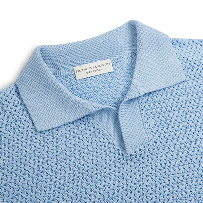 The Sky Blue Open Weave Skipper Polo by Filippo de Laurentiis features a textured geometric pattern, short pointed collar, and partial button placket. The inner label reads Filippo de Laurentiis Giza Cotton in gray text. , available at Richard Gelding Mayfair