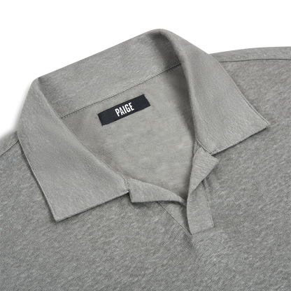 Close-up of the Light Grey Linen Capri Collar Polo Shirt by Paige, featuring textured fabric and a short placket—ideal for summer. The inner collar label displays "Paige" in white on black. White background. , available at Richard Gelding Mayfair