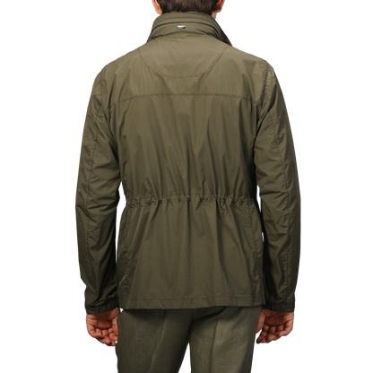 Seen from the back, a person wears Herno's Dark Green Ultralight Nylon Field Jacket with wind and rain resistance, featuring an elastic waistband.