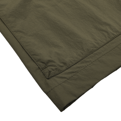 Close-up of the hem of a Herno Dark Green Ultralight Nylon Field Jacket on a white background, highlighting stitching details and hinting at its resistance to wind and rain.