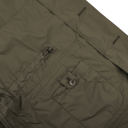 Close-up of dark green fabric with button and buckle details, featuring stitching and pleats; ideal for crafting a nylon piece. The Herno Ultralight Field Jacket offers wind and rain resistance.