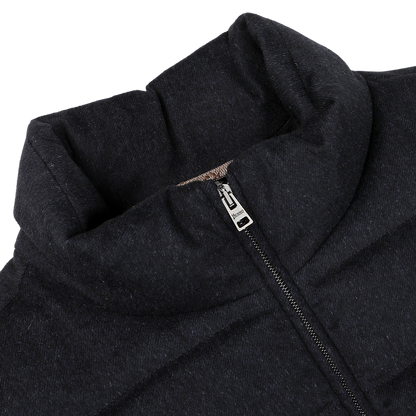Close-up of a navy blue, water-repellent cashmere silk bomber jacket by Herno, with a zipper partially unzipped, revealing the collar design and stitching details.