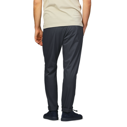 Back view of a person in a beige shirt and Herno's navy blue nylon stretch drawstring trousers, with hands in pockets.
