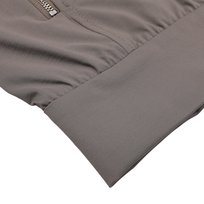 Close-up of a Taupe Beige Nylon Jersey Hood Jacket sleeve by Herno, featuring a visible zipper and elastic cuff on a white background.