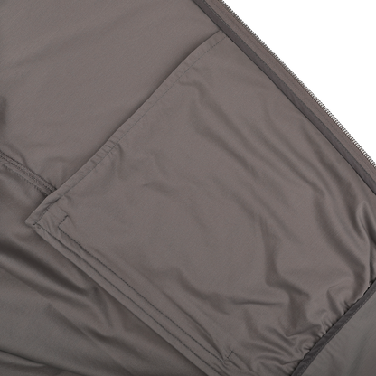 Close-up of a taupe beige fabric surface made from Herno's lightweight nylon jersey, featuring a stitched, rectangular pocket on the left side.