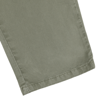 Close-up of a leg from the Green Washed Cotton Gabardine Slim Chinos by Hiltl, showcasing visible stitching near the hem.