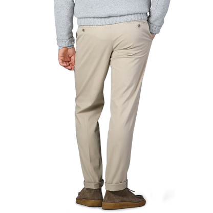 A person wearing Hiltl's Khaki Cotton Stretch Regular Fit Chinos paired with brown shoes is shown from the back. The trousers are complemented by a light gray sweater.