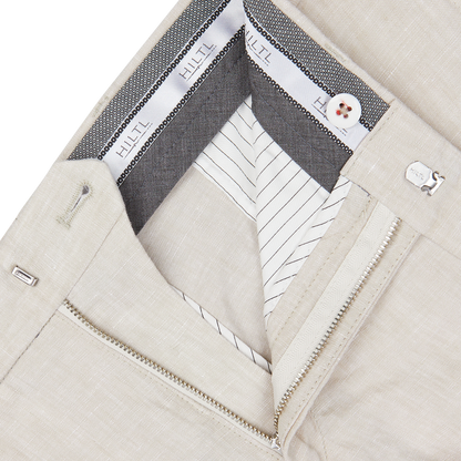 Close-up of a beige jacket with detailed inner lining, visible white shirt collar, and partial silver zipper paired with Hiltl Light Beige Washed Linen Regular Fit Chinos.
