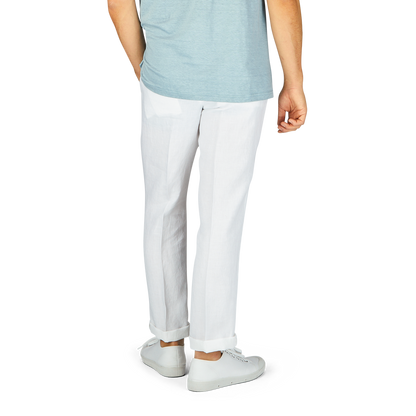 Man standing in a light blue t-shirt and Hiltl White Washed Linen Regular Fit Chinos with white sneakers, partial view showing from waist down.