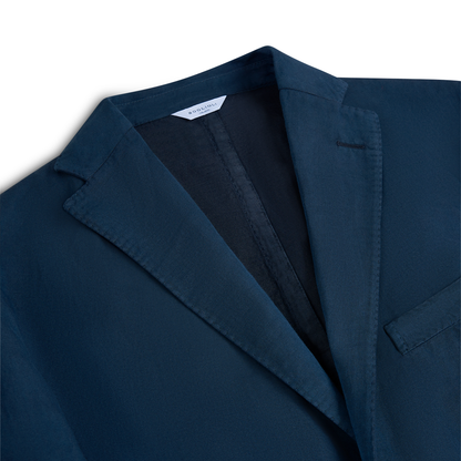 A close-up of the Boglioli Navy Blue Satin Cotton/Linen Jacket with notch lapels, visible stitching, a chest pocket, and a white label inside the collar. The fabric looks smooth and the tailoring is neat, set against a white background. , available at Richard Gelding Mayfair
