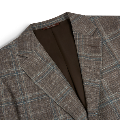 Close-up of the Canali Stone Teal Wool/Silk/Linen Windowpane Check Blazer, featuring light blue and beige stripes, notch lapels, brown lining, and a "Made in Italy" collar tag. The textured fabric is shown on a white background. , available at Richard Gelding Mayfair