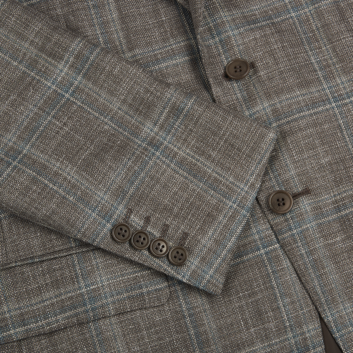 A close-up of the Canali Stone Teal Wool/Silk/Linen Windowpane Check Blazer sleeve, featuring four brown cuff buttons and two front buttons. The fabric displays a refined light blue and white check pattern highlighting its texture. , available at Richard Gelding Mayfair