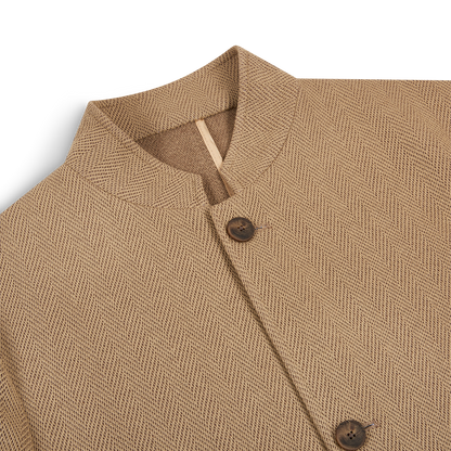 A close-up of the Gran Sasso Beige Herringbone Cotton Blend Jacket, featuring a short band collar and two brown buttons on the textured front, displayed against a white background with focus on the collar and upper chest. , available at Richard Gelding Mayfair