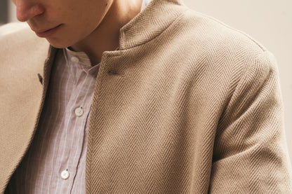 Close-up of a person wearing the Alessandro Gherardi Brown Stripe Linen Mandarin Collar Shirt, focusing on its fine striped fabric, neat stitching, and stylish design under a beige textured blazer. , available at Richard Gelding Mayfair