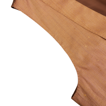 Close-up of a folded, textured fabric on a white background, showcasing its weave and hem, reminiscent of the luxurious feel of Lardini's Bronze Pure Silk DB Waistcoat.