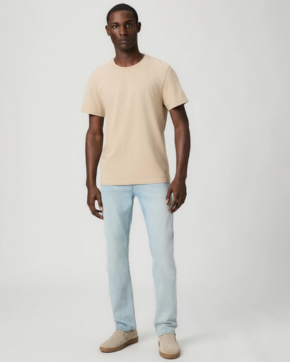 A man stands facing forward against a plain light background, wearing the Paige Natural Beige Cotton Sorden Crew Neck T-Shirt. His arms are relaxed at his sides and he has a neutral expression. , available at Richard Gelding Mayfair