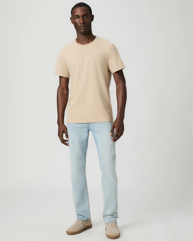 A man stands facing forward against a plain light background, wearing the Paige Natural Beige Cotton Sorden Crew Neck T-Shirt. His arms are relaxed at his sides and he has a neutral expression. , available at Richard Gelding Mayfair
