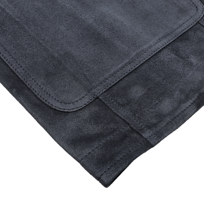 Close-up of a folded dark gray fabric mat with visible stitching details, echoing the meticulous craftsmanship of Manto's Denim Blue Suede Unlined Jacket, on a white background.