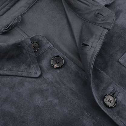 Close-up of a denim blue suede jacket by Manto featuring three black buttons and folded collar details, showcasing its slim fit design.