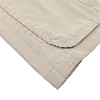 Close-up of a neatly folded Manto Khaki Beige Ultrafine Microfibre Safari Jacket, showing visible stitching, set against a white background.