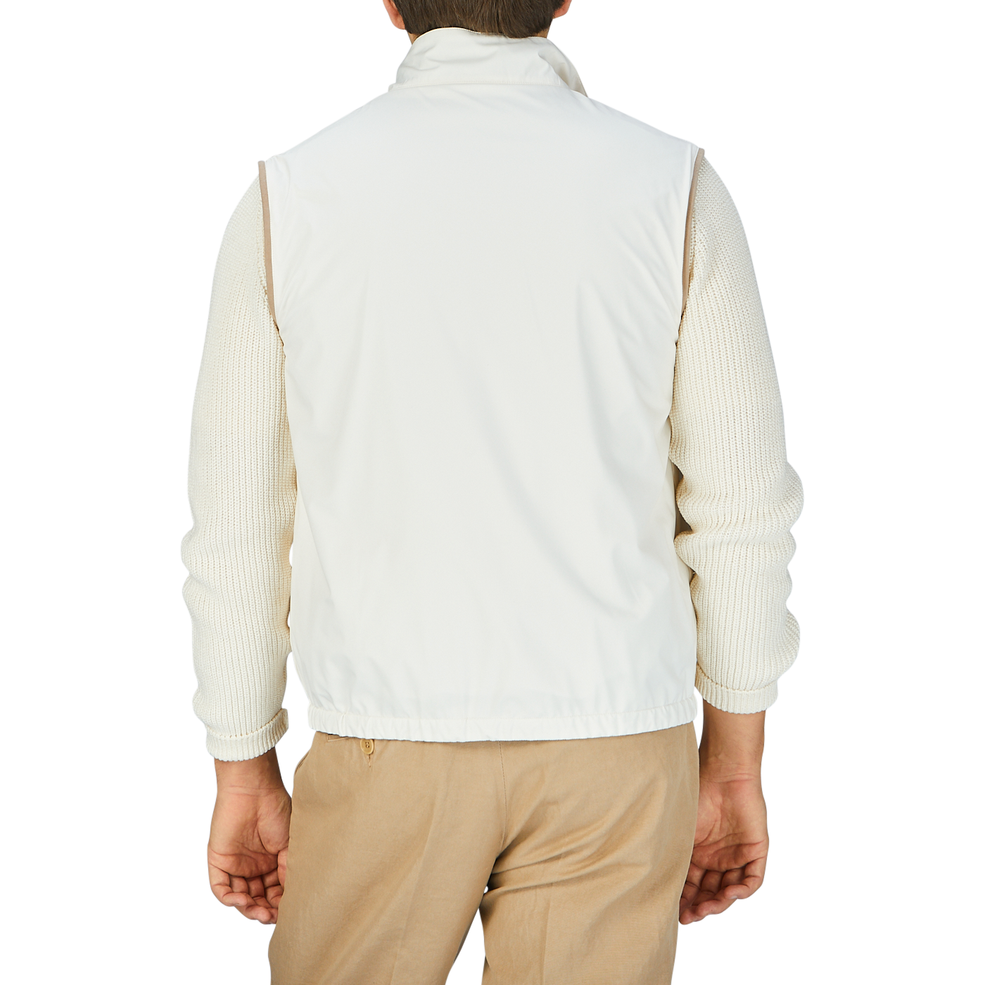 The man is wearing a white Beige Reversible Loro Piana Cashpima Gilet and tan pants by Manto.