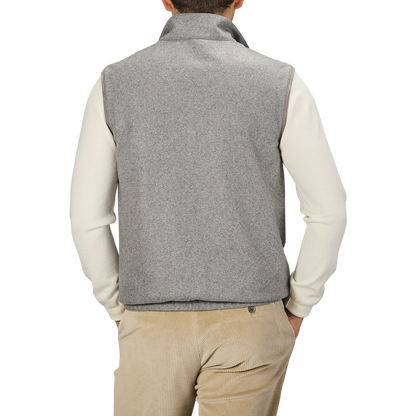 A person wearing a Manto Grey Beige Cashmere Nylon Reversible Gilet over a white long-sleeve shirt and beige corduroy pants stands with their back to the camera.