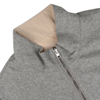 A close-up of the Manto Grey Beige Cashmere Nylon Reversible Gilet, showcasing its luxurious beige lining. The gilet is partially unzipped and lying flat on a light-colored surface.